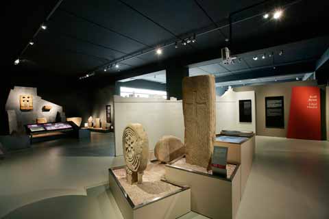 Espacio expositivo, con estelas funerarias correspondientes a la alta edad media. Al fondo se observa la reconstrucción del interior de una iglesia con altar, epígrafe fundacional y ventana.