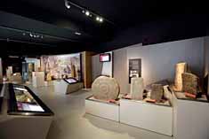 Zona de exposición, donde se muestran estelas de piedra con relieves y expositores con diferentes utensilios, correspondiente a la edad de hierro.