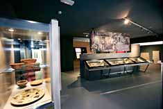 Espacio expositivo, con recipientes de cerámica expuestos en vitrinas, correspondientes a la época romana.